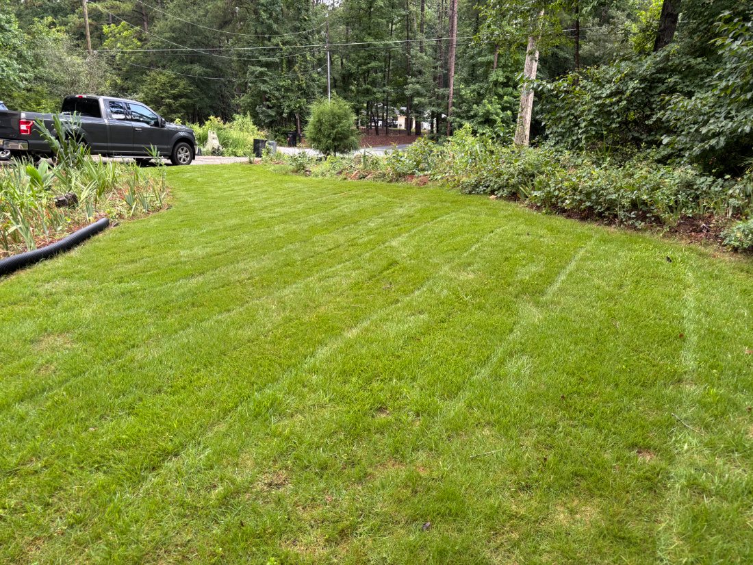 Striped back lawn with the work truck parked at the edge